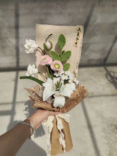 someone holding a bouquet of flowers in their hand