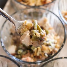 a spoon full of food sitting on top of a glass bowl next to other dishes