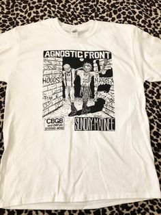 Agnostic Front Vintage Flyer T-Shirt. Artwork taken from a vintage show flyer that took place at CBGB's in New York during the mid 1980's with Nausea and NY Hoods. Hand screened on a White 100% Cotton Tee. Band Merch Screen Print Shirt For Fan Conventions, Cotton Graphic Shirt For Fan Conventions, Grunge Fan Merchandise Shirt With Screen Print, Grunge Style Fan Merchandise Shirt With Screen Print, 90s Style Screen Print T-shirt For Fan Conventions, Grunge Graphic Print Shirt For Fans, Retro Graphic Print Shirt For Fan Merchandise, Retro Graphic Print Shirt For Fans, Vintage Shirt With Graphic Print For Fans