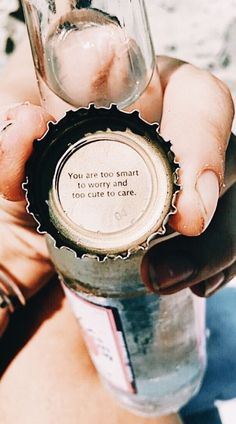 a person holding a bottle cap with a message on it