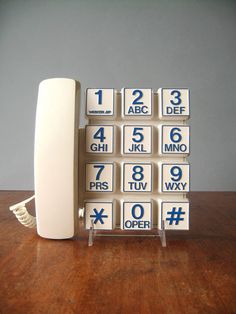 an old fashioned phone is sitting on a table with the number nines in front of it