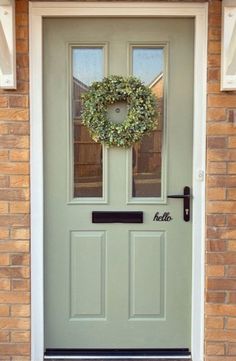 a green front door with a wreath on it