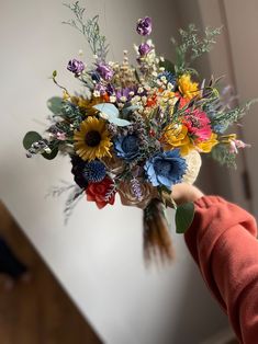 a person holding a bouquet of flowers in their hand