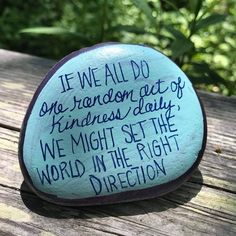 a rock with writing on it sitting on top of a wooden table