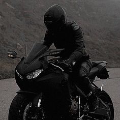 a man riding on the back of a black motorcycle