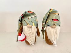 two gnomes with hats on their heads and one has a red ball in its mouth