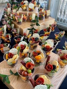 a table topped with lots of food on top of wooden trays filled with different types of foods