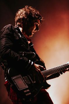 a man playing a guitar on stage at a concert