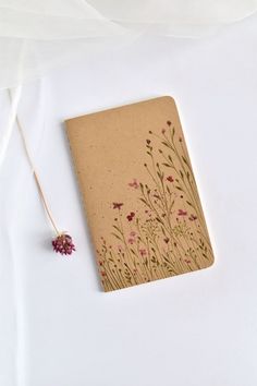 a notebook with flowers on it next to a string