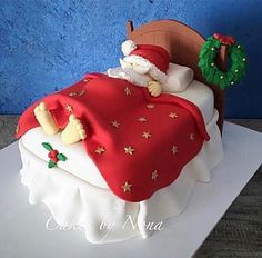 a cake that is shaped like a bed and has a santa clause on the top