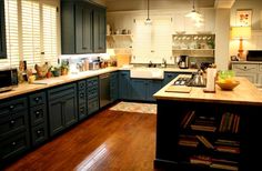 a kitchen with wooden floors and blue cabinets