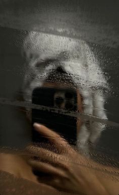 a person taking a selfie in front of a mirror with water splashing on it