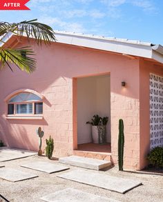 a pink house with a cactus in the front yard and a window on the side