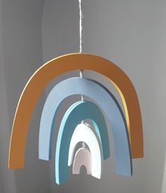 a multicolored wooden wind chime hanging from a ceiling in a room with white walls