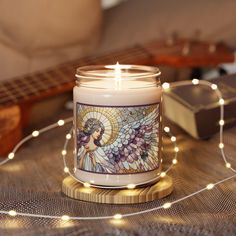 a candle that is sitting on a table next to some string lights and a guitar