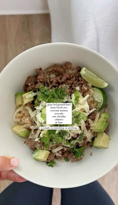 a person is holding a bowl full of food with an ad on the side in front of them