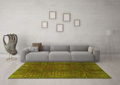 a living room with a gray couch and green rug