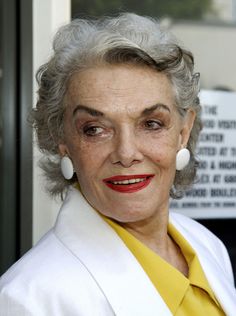 an older woman with grey hair and yellow shirt