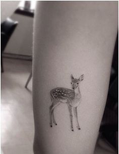 a small deer tattoo on the left calf's leg is shown in black and white