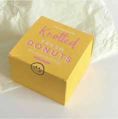 a box that has some kind of doughnut in it on a white tablecloth