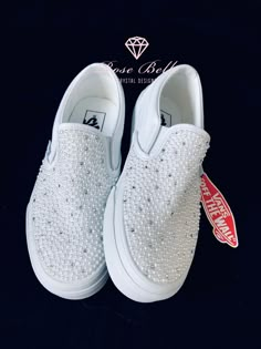 a pair of white shoes with pearls on them