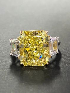 a fancy yellow diamond ring sitting on top of a table