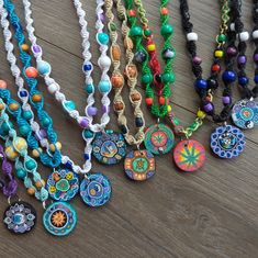 many colorful necklaces are displayed on a wooden table