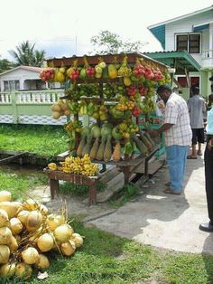 a man standing next to a fruit stand filled with bananas