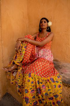 "This full-length, sleeveless dress, made from luxurious cotton, offers both comfort and style and is the epitome of a classic colour blocked dress. With two side pockets, a waist belt for a perfect fit, and a tiered design with lining, it embodies grace and sophistication while being fun. The delightful combination of bhoota prints and vibrant blooming florals evokes a sense of romance and the carefree spirit of summer. Our favourite dress for wedding guests! This dress comes in two colour variations. There are only 30 pieces made so this dress is truly one of a kind! Check our website for more details on our brand and how we work with fair trade. www.raahiliving.com Sangeeta is 5'9\" and wears size S. 100% Organic cotton Waist belt detail Fitted bodice Sleeveless Side pockets Lined Hand- Sundress Women, Summer Dress Floral, Printed Summer Dresses, Colour Blocking, Maxi Robes, Floral Color, Women Maxi, Colorblock Dress, Floral Dress Summer