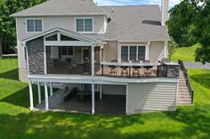 an aerial view of a two story house with a deck and outdoor dining area on the second floor