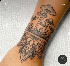 a tattoo on the foot of a woman with mushrooms