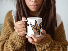 a woman holding a coffee mug with two hands