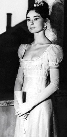 an old black and white photo of a woman in a dress