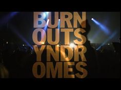 the words burn outs and yndr omes are projected in front of a stage