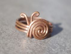 Humble but efective and extraordinary copper wire ring. Like in the pictures made of copper wire diameter 1,2mm. Instead of gemstone there is a little snail made of wire. This little gadget will surely get attention of Your friends on the party or used as an everyday wear. Variety of sizes availabel - please specify the diameter You are intrested in. Opinions about the healthy effects of copper on the human body are quite popular and many of them can be found in the internet. Buying our ring, You receive in addition to potential health properties also a nice piece of exclusive jewelry, which is suitable for everyday wear as well as for special occasions, especially among those who appreciate the uniqueness of handcrafts. Cleaning: This is uncoated copper so it will tarnish. Many people lik Copper Wire Ring, Copper Wire Crafts, Diy Wire Jewelry Rings, Wire Jewelry Patterns, Wire Jewelry Rings, Wire Craft, Wire Jewelery, Wire Wrap Jewelry Designs, 2024 Ideas