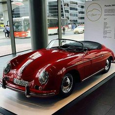 a red sports car is on display in a museum