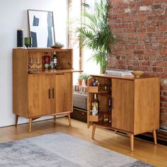 a wooden cabinet sitting next to a window filled with bottles and glasses on top of a hard wood floor