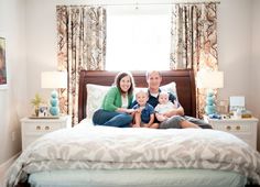 the family is sitting on their bed together