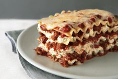 two pieces of lasagna stacked on top of each other with sauce and cheese