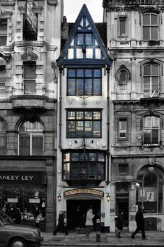 an old black and white photo of people walking in front of a building