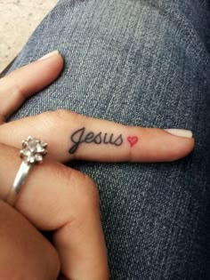 a woman's hand with a small tattoo that says jesus on the middle finger