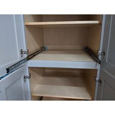 an empty pantry with white cupboards and drawers