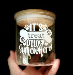 a person holding a glass jar with some writing on it's lid and the words, it's treat o clock somewhere