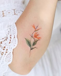 a woman's arm with a flower tattoo on the left side of her arm