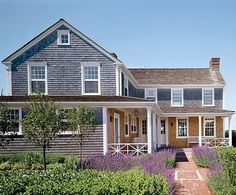 a house that is in the middle of some flowers