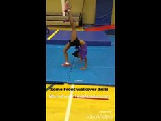 a woman is doing a handstand on a trampoline