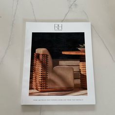 a magazine with an image of a chair and table in the middle on a marble surface