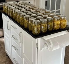 jars filled with pickles on top of a kitchen island