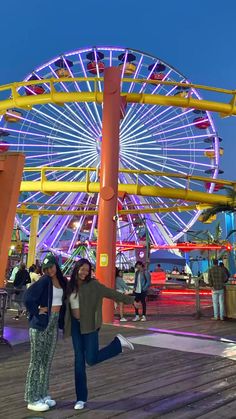 two women standing in front of a ferris wheel