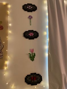 some pixel art hanging on the wall with string lights around it and a skull in the background